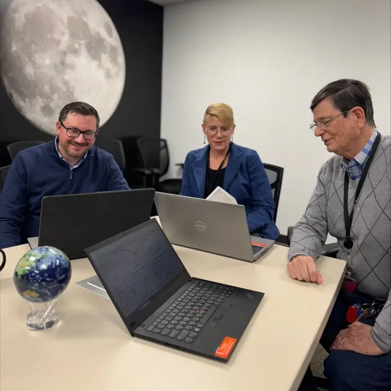 IBR scientists, Drs. Hursh, Devine, and Reed engaged in a strategic consulting meeting at a conference table, equipped with analytical tools, focusing on fatigue risk management, and behavior economics solutions.